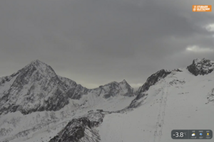 Zaśnieżone szczyty nad lodowcem Stubai przy pochmurnym niebie